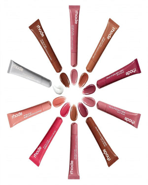 Rhode lip color set arranged in a circular pattern on a white background, featuring multiple nude, pink, and brown lipsticks in squeeze tubes with corresponding color swatches in the center.