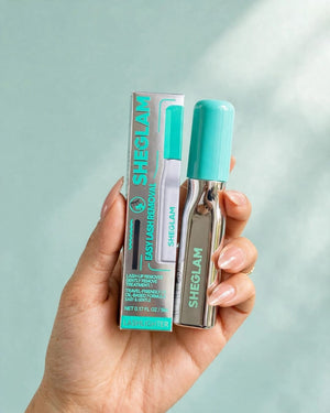 SHEGLAM EZ Remove Lash Treatment lifestyle hand holding original box and silver bottle teal cap travel friendly gentle removal